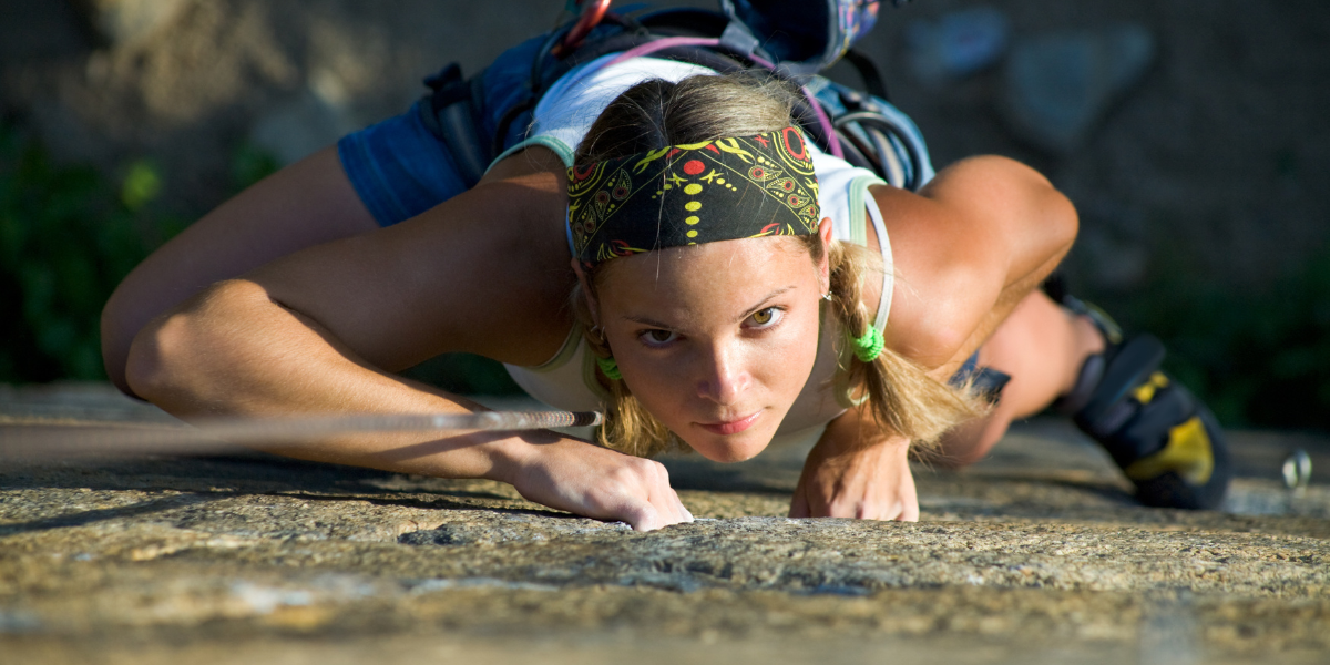 A woman climbing a steep wall